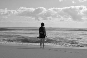 Mulher na praia olhando para o mar