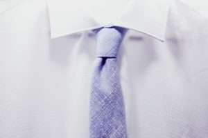 Zoom de uma gravata azul sobre um terno branco
