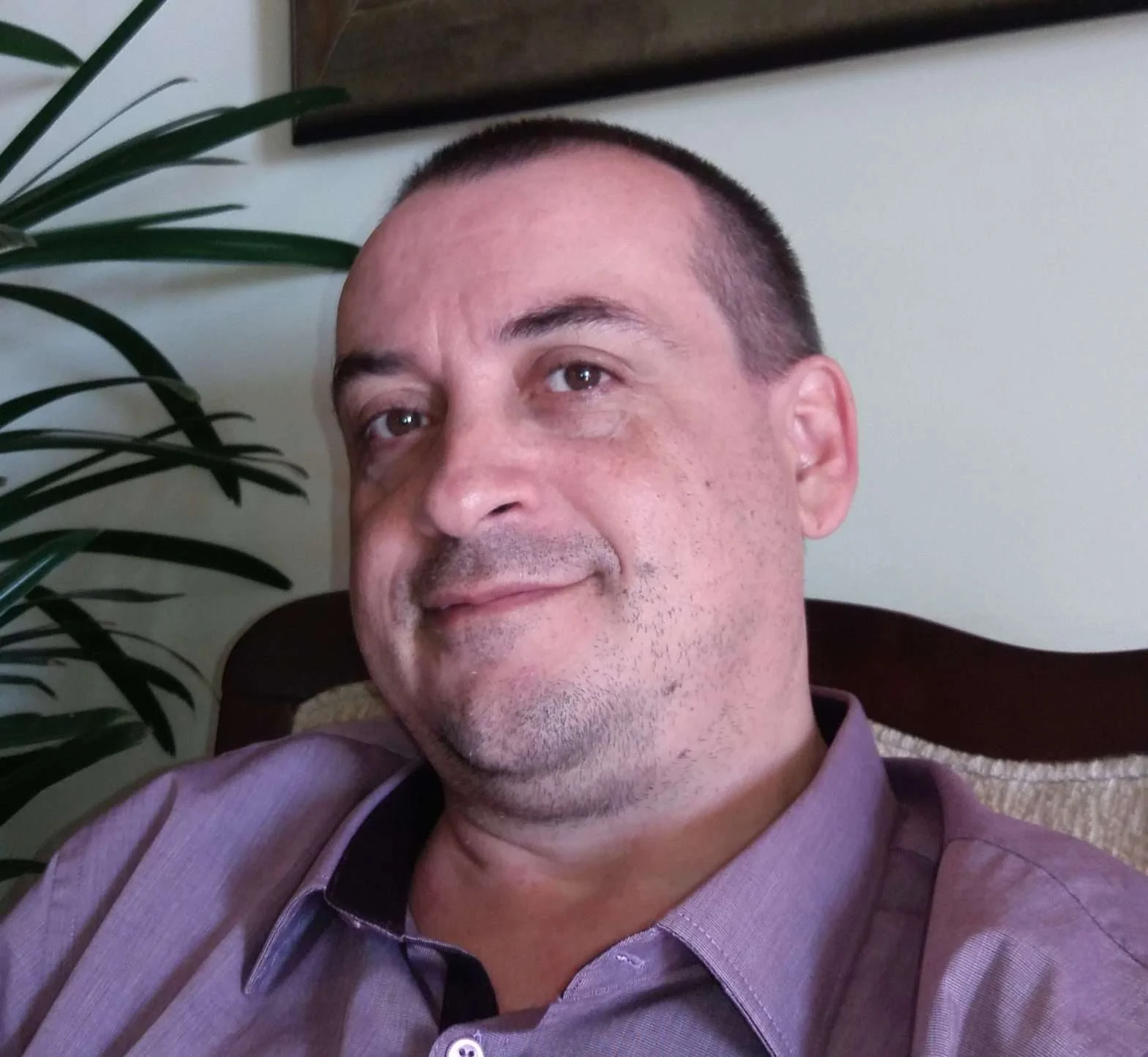 Psicólogo Emilson Silva com camisa roxa e sorrindo