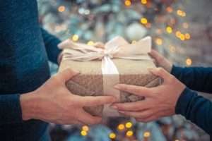 Um homem entregando um presente de Natal para uma mulher