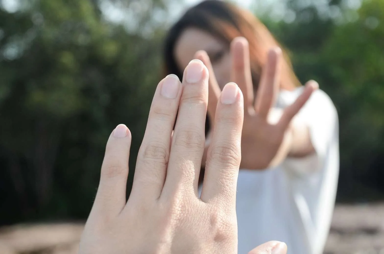 Um homem e uma mulher mostrando a palma de suas mãos um para o outro