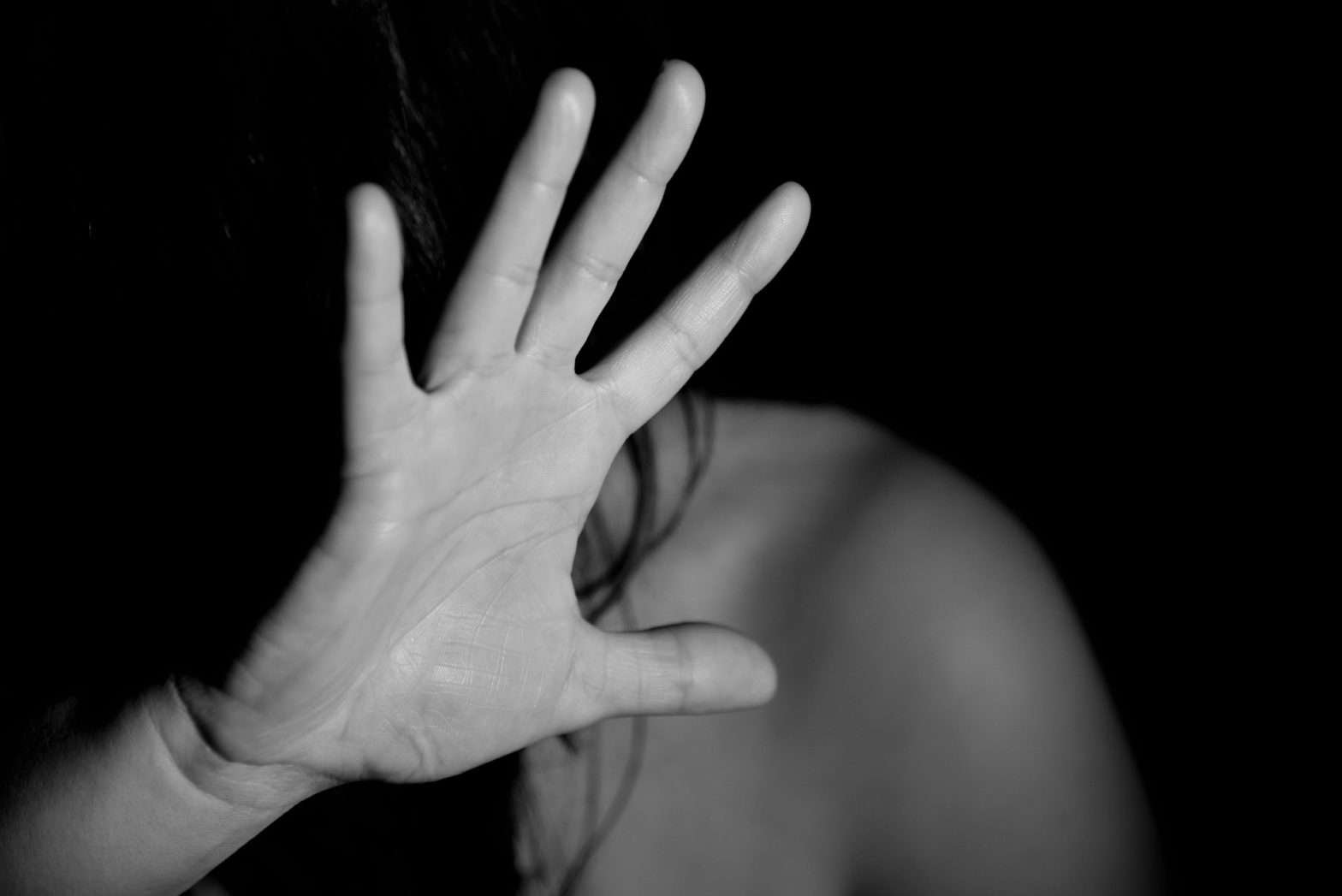 Foto em preto e branco de uma mulher com a mão em frente ao rosto