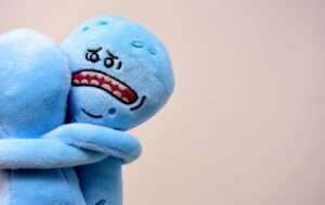 Boneco azul com a cara triste abraçando outro boneco azul