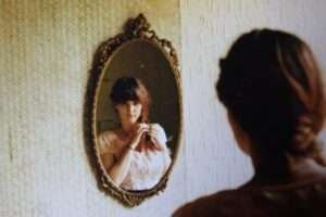 Foto antiga de uma mulher se olhando em um espelho