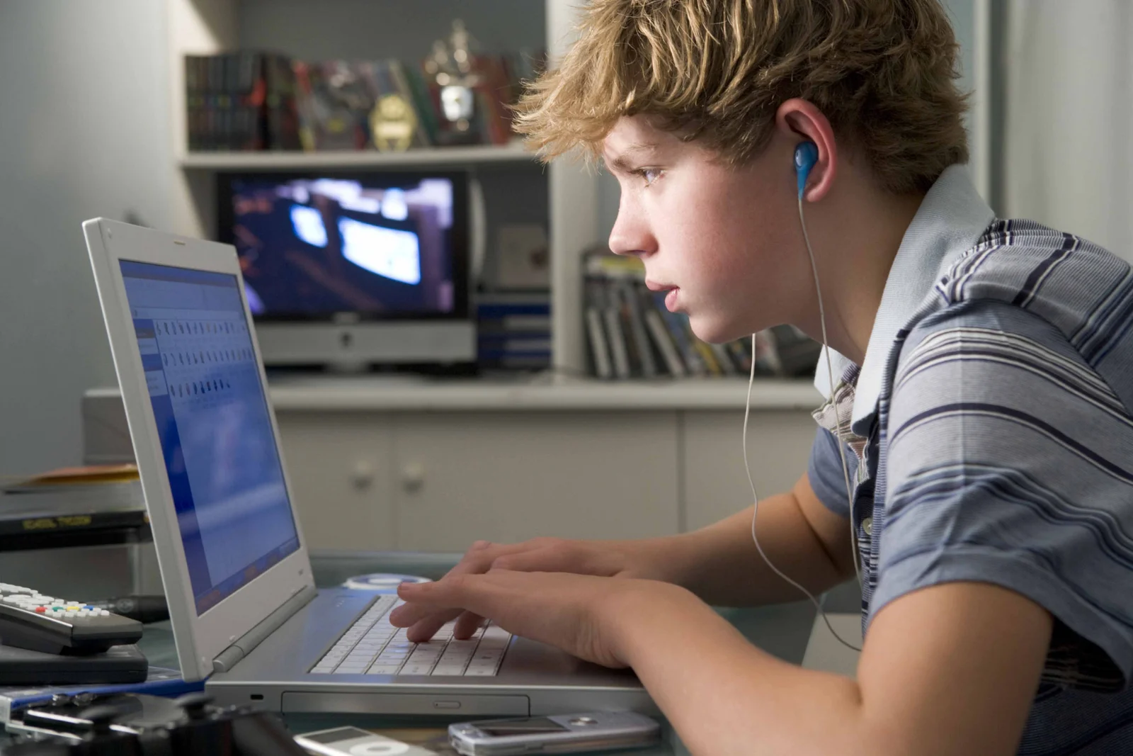 Um jovem usando um notebook e usando fones de ouvido