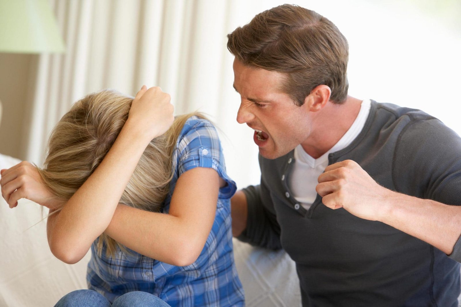 Um homem ameaçando uma mulher com agressão física