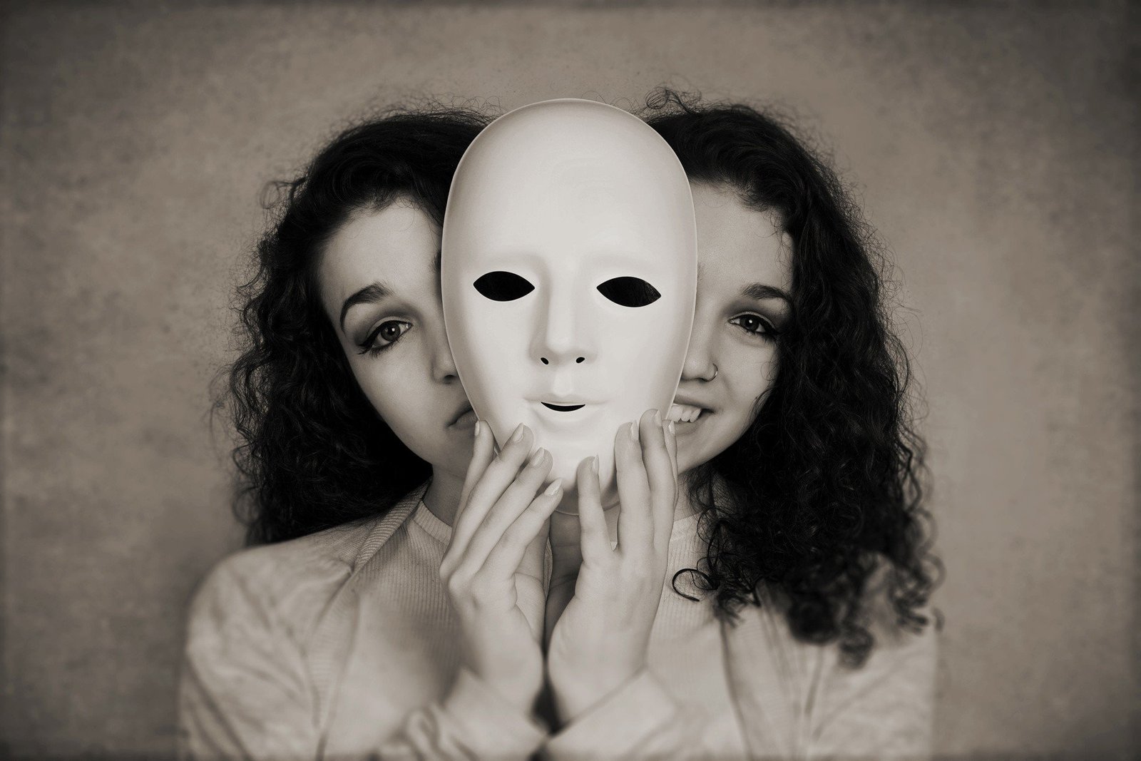Mulher segurando uma máscara enquanto ao fundo ela tem uma expressão triste e feliz