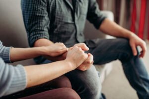 Uma Psicóloga fortalecendo a aliança terapêutica ao segurar a mão de seu paciente