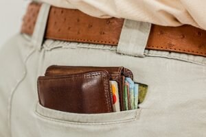 Carteira com vários cartões e dinheiro no bolso de uma calça