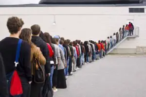 Uma fila de pessoas esperando para entrar em uma porta branca