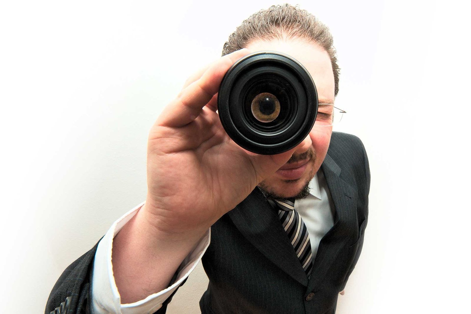 Um homem de terno e gravata olhando através de uma luneta
