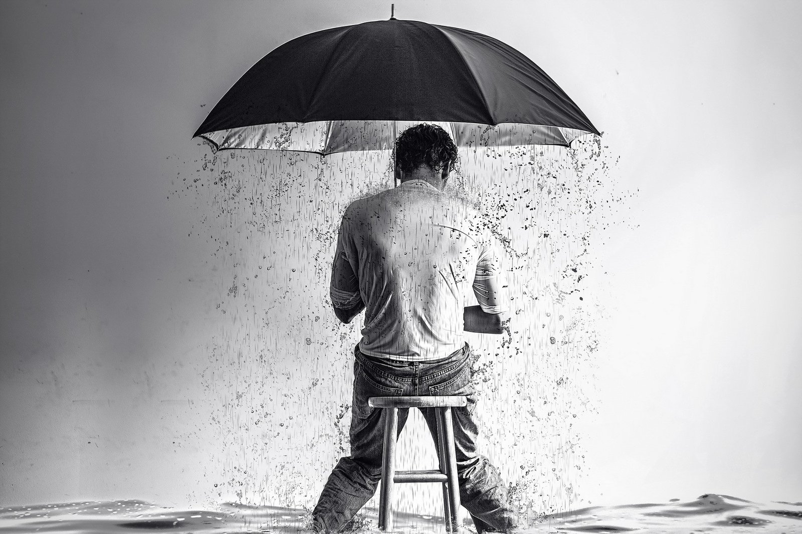 Homem sentado em um banco enquanto segura um guarda-chuva que derrama água de dentro dele
