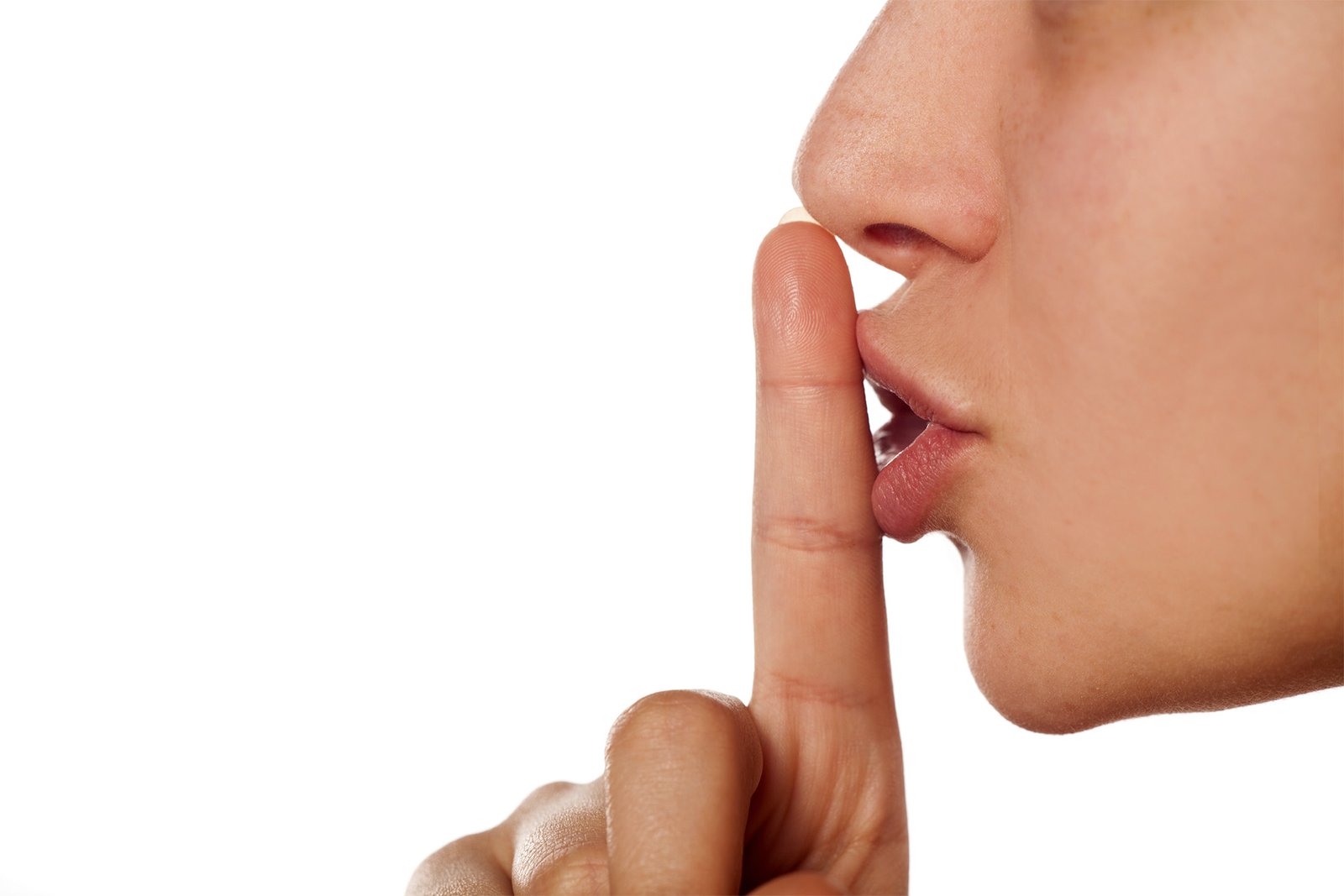 Perfil do rosto de uma pessoa com o dedo em posição vertical, sinalizando silêncio