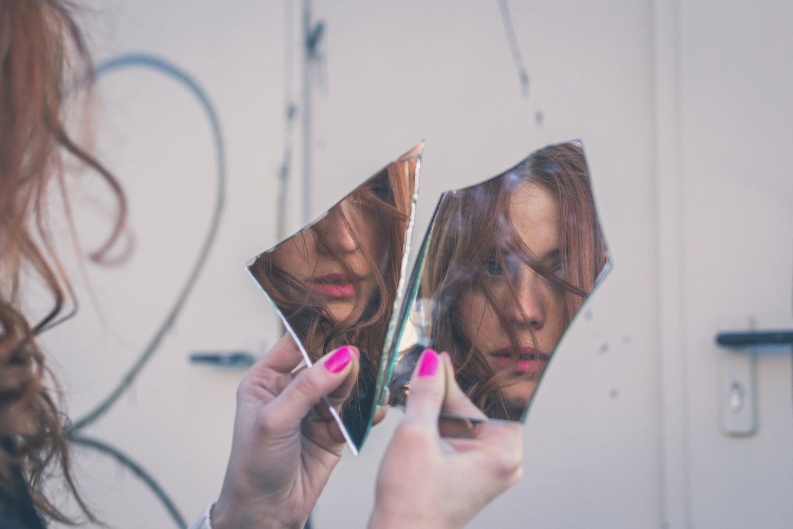 Uma mulher narcisista olhando para um espelho quebrado