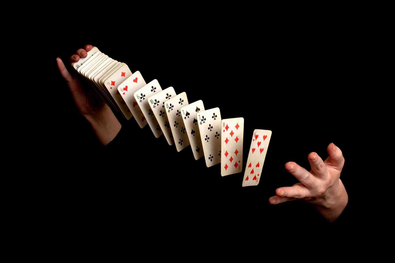 Mãos de um mágico fazendo truques com um baralho