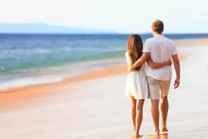 Uma mulher se tornando inesquecível para um homem enquanto caminham na praia