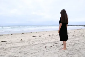 Uma mulher em uma praia se sentindo sozinha em seu relacionamento